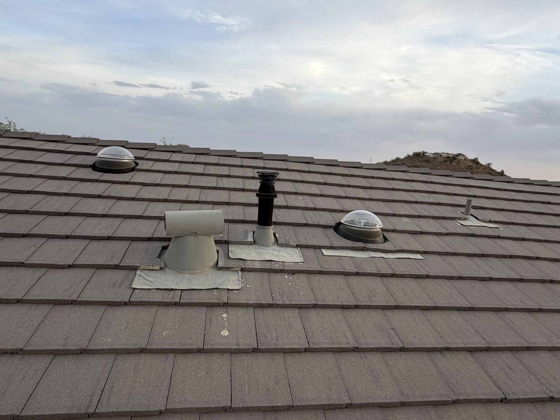 Flat concrete tile roof with mountains behind