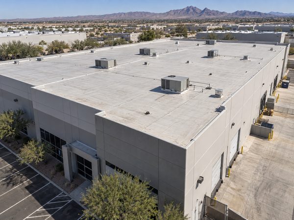 Elevated view of a low-slope commercial roof and HVAC equipment in an Arizona industrial area.